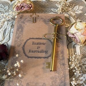 Vintage journal with decorative key and flowers.